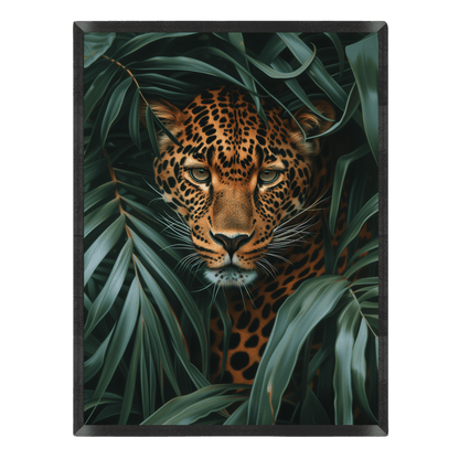 Leopard peeking through green leaves with a dark frame